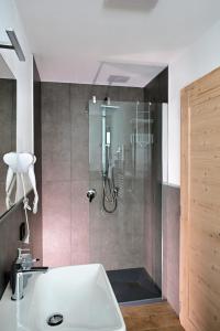 a bathroom with a shower and a white sink at Mas dei Masi in Cavalese