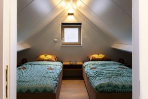 um quarto com 2 camas num sótão em Casa di Luna em Middelkerke