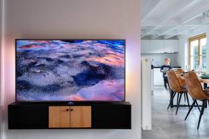 een grote flatscreen-tv aan een muur in een woonkamer bij Casa di Luna in Middelkerke