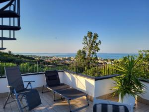 uma varanda com cadeiras e vista para o oceano em Villa Lida Apartment in collina con ampio terrazzo vista mare em Giulianova