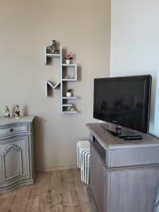 uma sala de estar com uma televisão de ecrã plano num centro de entretenimento em Villa Lida Apartment in collina con ampio terrazzo vista mare em Giulianova