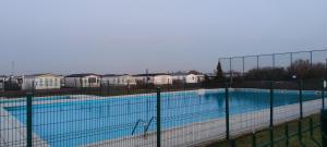 a large swimming pool with a fence around it at Blauwe Lagune in De Haan