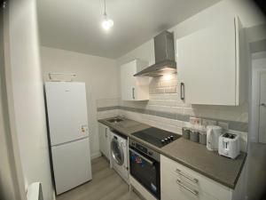 a small kitchen with a stove and a refrigerator at Relaxing Modern Apartment, Sheffield, Free Parking in Sheffield