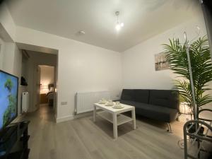 a living room with a black couch and a table at Relaxing Modern Apartment, Sheffield, Free Parking in Sheffield