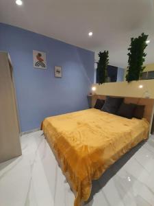 a bedroom with a yellow bed in a blue wall at Salavantinas House in Tavronitis