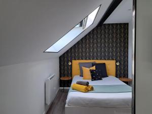 een slaapkamer met een bed en een dakraam bij Bienvenue à Reims type studio charmant et lumineux 2eme étage in Reims