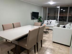 une salle à manger avec une table et des chaises blanches dans l'établissement Condominio Costa Peñuelas, à Coquimbo