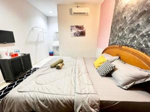 ein Schlafzimmer mit einem großen Bett mit Kissen darauf in der Unterkunft Little Chenang Cottage Motel Langkawi in Pantai Cenang