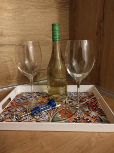 Una botella de vino y dos copas en una mesa. en Studio Sunset, en Voždivac