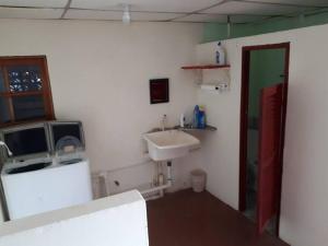 a small bathroom with a sink and a mirror at Gia's Garage & Home for Bocas travelers in Almirante