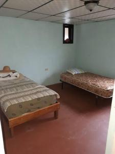 two beds sitting in a room with at Gia's Garage & Home for Bocas travelers in Almirante