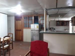 cocina con nevera, mesa y sillas en Gia's Garage & Home for Bocas travelers, en Almirante