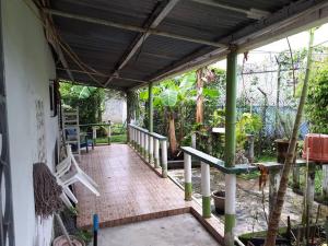 a porch of a house with green pillars at Gia's Garage & Home for Bocas travelers in Almirante