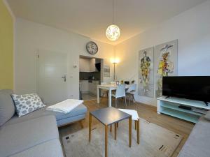 sala de estar con sofá, mesa y reloj en Stilvolle, charmante Ferienwohnung in Plauen, en Plauen