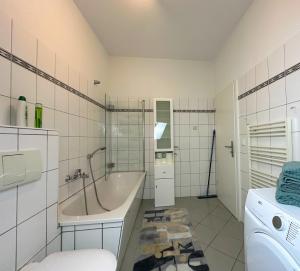 a bathroom with a tub and a washing machine at Stilvolle, charmante Ferienwohnung in Plauen in Plauen