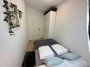 a small bedroom with a bed and two pillows at Stilvolle, charmante Ferienwohnung in Plauen in Plauen