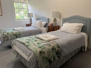una camera da letto con due letti con asciugamani sopra di Tahara Cottage a Deloraine