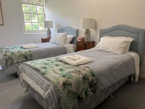 a bedroom with two beds with towels on them at Tahara Cottage in Deloraine