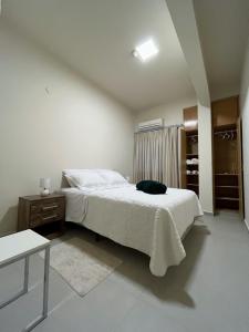 Dormitorio blanco con cama y armario en Cerca de todo, en Ciudad del Este