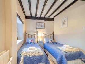2 łóżka w sypialni z niebiesko-białymi ścianami w obiekcie The Old Sweet Shop w mieście Richmond
