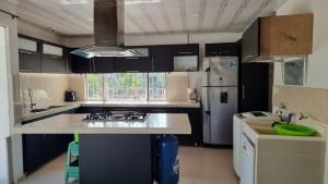 eine Küche mit schwarzen Schränken und einer weißen Arbeitsplatte in der Unterkunft PLAYABRISAMAR in San Antero