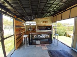 una gran cocina al aire libre con fogones y taburetes en Cabaña El Campito en Salta