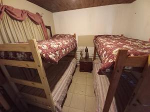 1 dormitorio con 2 literas y suelo de baldosa en Cabaña El Campito en Salta