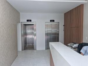 a room with two glass elevators in a building at APTO CENTRO GUARAPARI in Guarapari