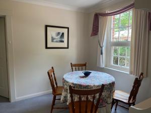 a dining room with a table and chairs and a window at Tahara Cottage in Deloraine