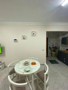 New Cairo lux apt in lux villa basement1 في القاهرة: طاولة بيضاء وكراسي في غرفة