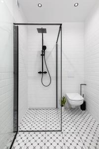 a bathroom with a shower and a toilet at Spacious Apartment with Swimming Pool, Gym and Sauna WWA40 in Warsaw