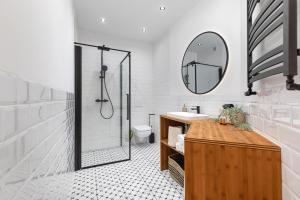 a bathroom with a shower and a sink and a mirror at Spacious Apartment with Swimming Pool, Gym and Sauna WWA40 in Warsaw