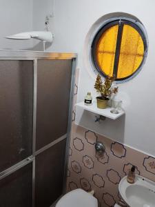baño con aseo y lavabo y ventana en Suíte c/ acesso independente, 4 quadras do mar!, en Torres