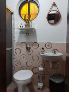 y baño con aseo y lavamanos. en Suíte c/ acesso independente, 4 quadras do mar!, en Torres