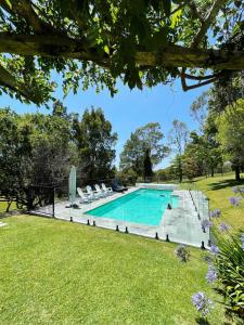 a swimming pool in a yard with chairs and trees at Tantallon in Berry