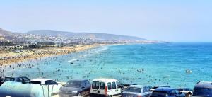 a beach with a lot of people in the water at Tigmi surf morocco in Tiguemmi nʼAït Bihi