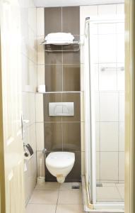 a small bathroom with a toilet and a shower at Kosar Hotel in Denizli