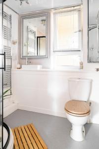 a bathroom with a toilet and a tub and a sink at Lovely 1-bedroom property with balcony in West end in Glasgow