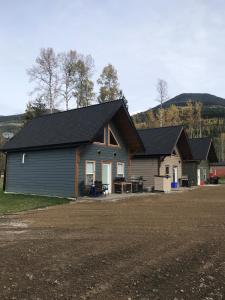 a house with a black roof and a driveway at Cougar Mountain Cabin Rentals in Valemount