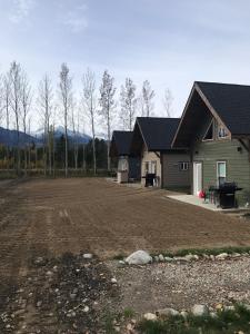 ein Haus mit einem unbefestigten Hof vor einem Haus in der Unterkunft Cougar Mountain Cabin Rentals in Valemount