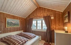 a bedroom with wooden walls and a bed with a window at Beautiful Home In Sjusjøen With Wifi in Sjusjøen +13 photos