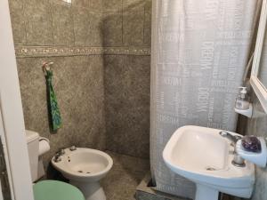La petite salle de bains est pourvue d'un lavabo et de toilettes. dans l'établissement El Refugio departamento 2, à Luján
