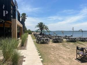 una fila de mesas y sillas en la playa en Depto La Leda en Almafuerte