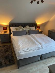 a bedroom with a bed with white sheets and pillows at B1 Ith Apartment in Coppenbrügge