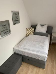a bedroom with a bed and a bench next to a wall at B1 Ith Apartment in Coppenbrügge
