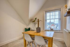 uma sala de jantar com uma mesa de madeira e cadeiras brancas em 1 or 2 bed in Folkestones West End em Folkestone