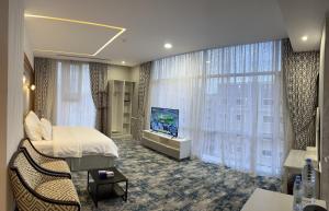 a hotel room with a bed and a flat screen tv at Rooms Hotel in Jeddah