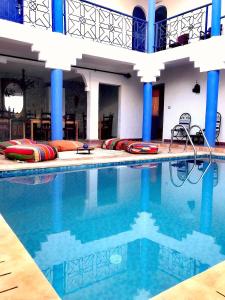 a swimming pool in a hotel with blue columns at Tigmi surf morocco in Tiguemmi nʼAït Bihi