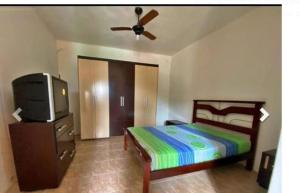 1 dormitorio con 1 cama y TV de pantalla plana en Casa Leivas, en Río Grande