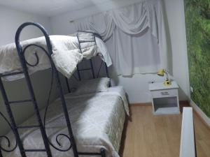 1 dormitorio con litera de metal y ventana en Departamento Parque la Libertad, en Cuenca